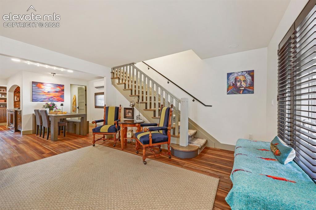 Image 7 of 30: Hardwood flooring throughout the main level, staircase with wood banister, 