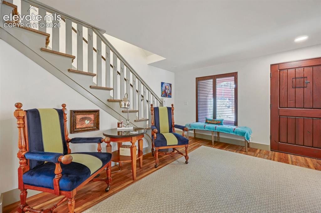 Image 8 of 30: Wood-finish flooring, staircase with painted risers and wood treads, built-