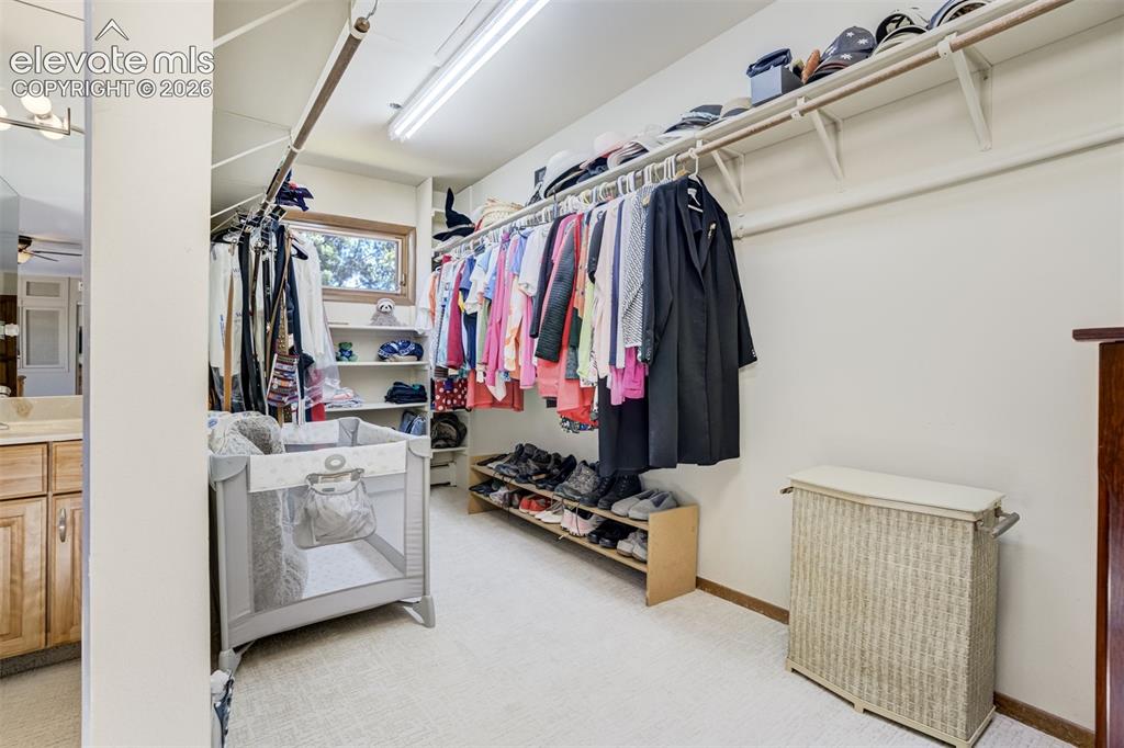 Image 28 of 50: Walk in closet with a bright window in the primary bedroom