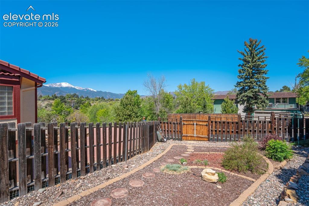 Image 46 of 50: Lovely Zeriscaping with gate access from driveway.