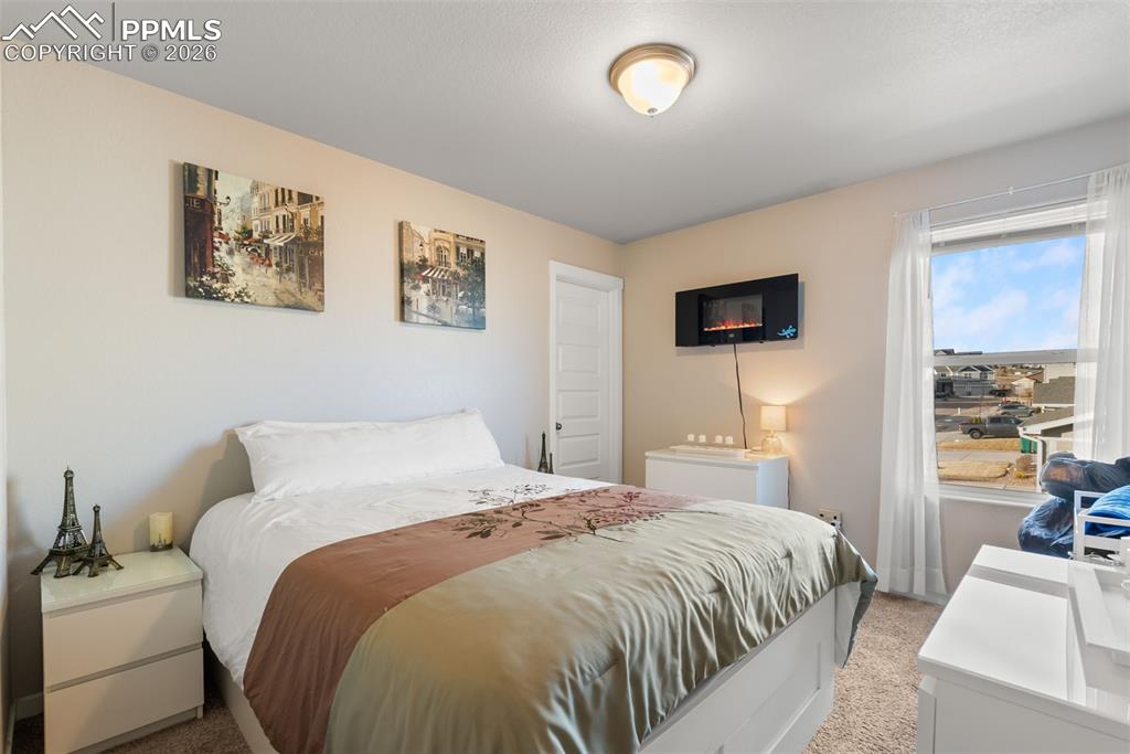 Image 16 of 33: Upper-level bedroom with natural light.