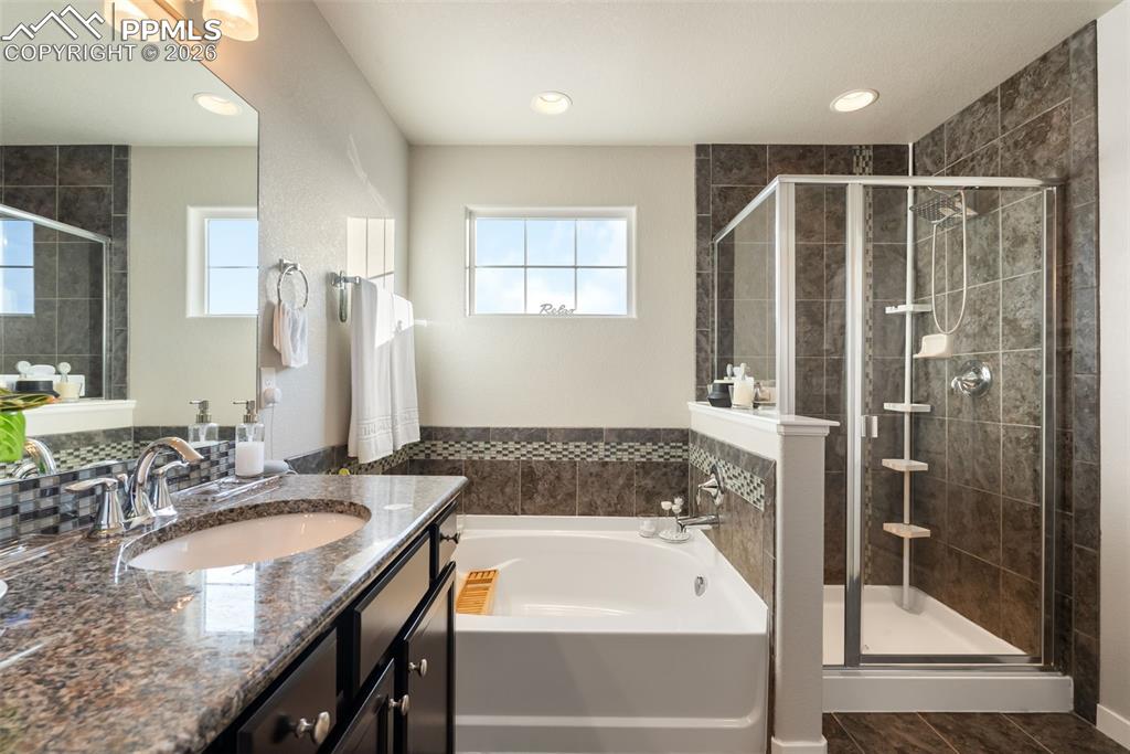 Image 23 of 33: Spacious five-piece primary bath with separate tub and shower.