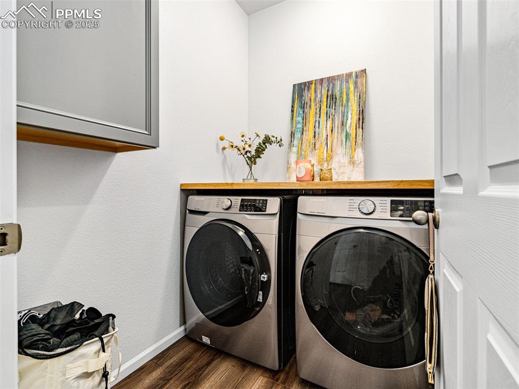 Image 18 of 26: Laundry area featuring dark wood-style flooring, washer and clothes dryer, 