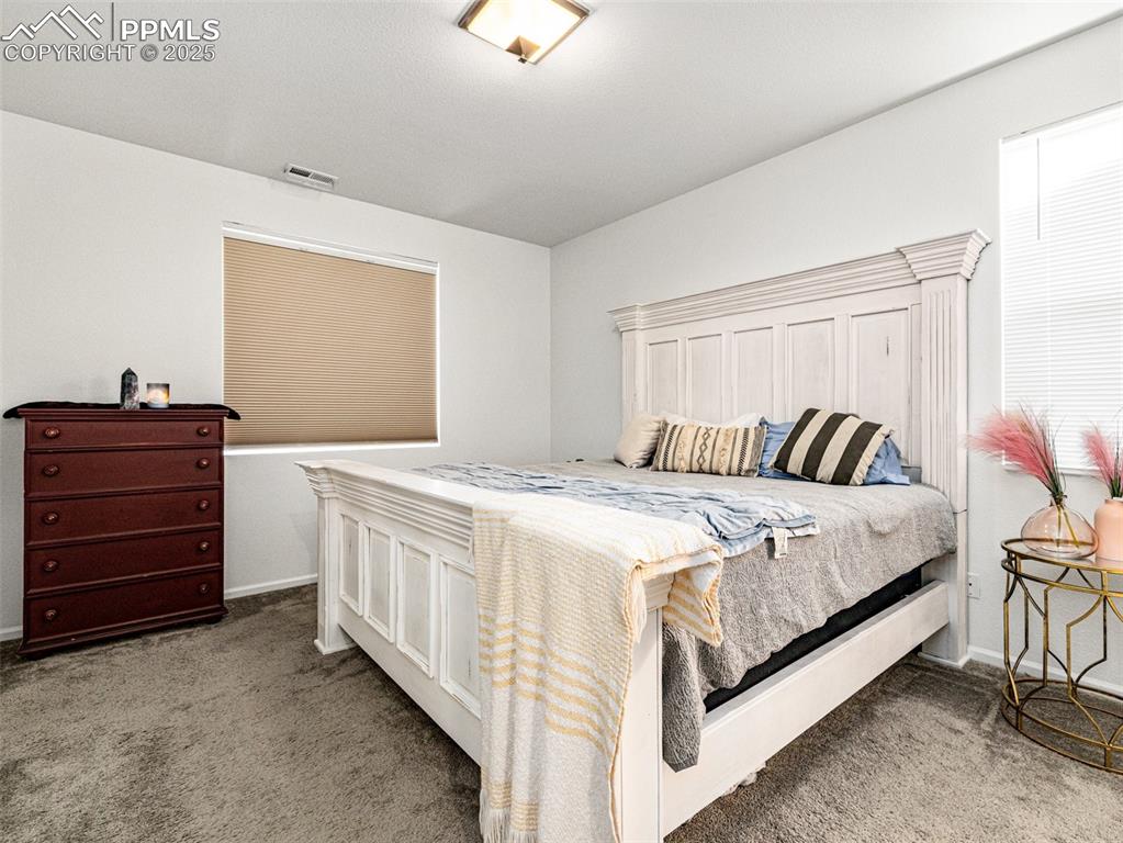 Image 19 of 26: Bedroom with light colored carpet and baseboards