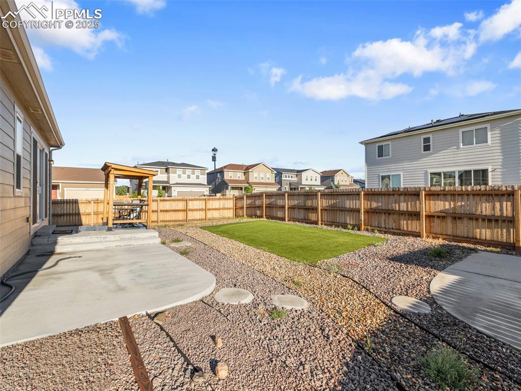 Image 24 of 26: Fenced backyard featuring a residential view and a patio