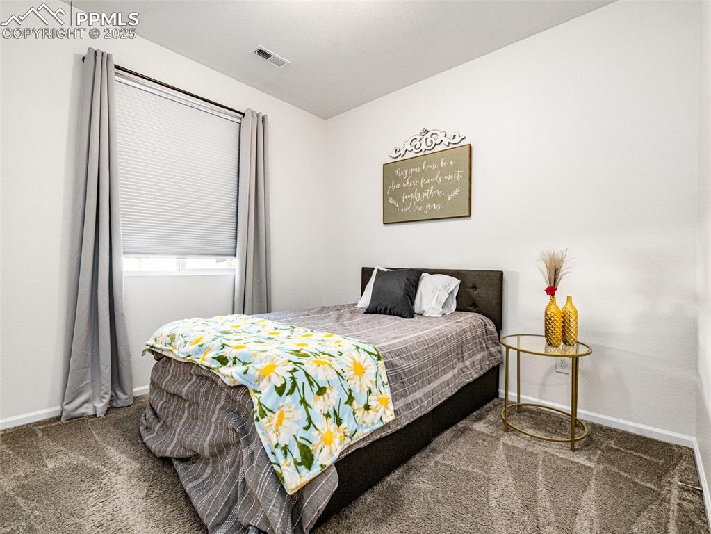 Image 7 of 26: Bedroom with baseboards and dark colored carpet