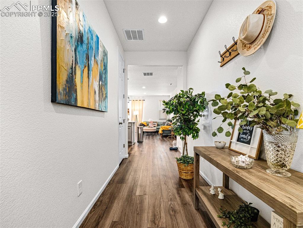 Image 9 of 26: Hallway featuring a textured wall, dark wood-type flooring, and recessed li