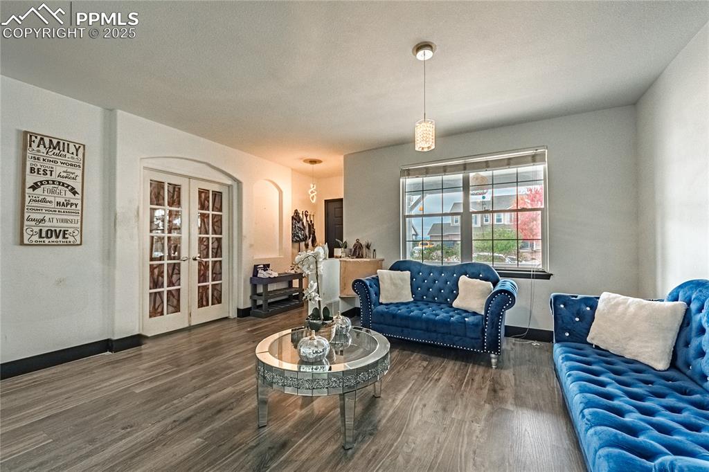 Image 10 of 47: Living area featuring wood finished floors, french doors, and arched walkwa