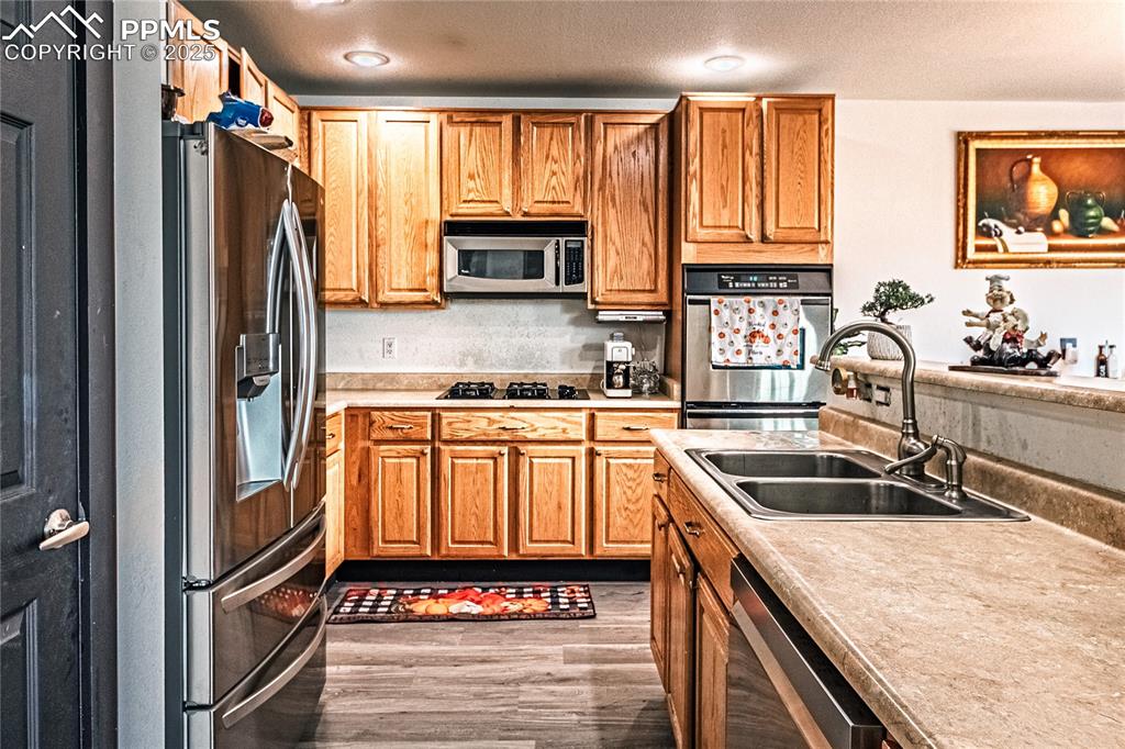 Image 21 of 47: Kitchen with light countertops, stainless steel appliances, light wood-styl