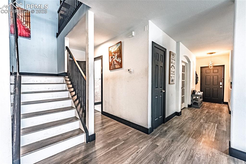 Image 26 of 47: Stairway with wood finished floors and a textured ceiling