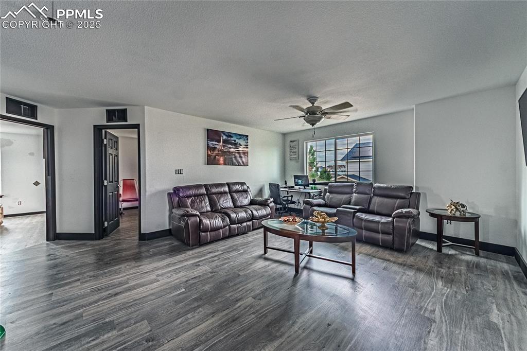 Image 28 of 47: Living room with dark wood-style flooring, a textured ceiling, and a ceilin