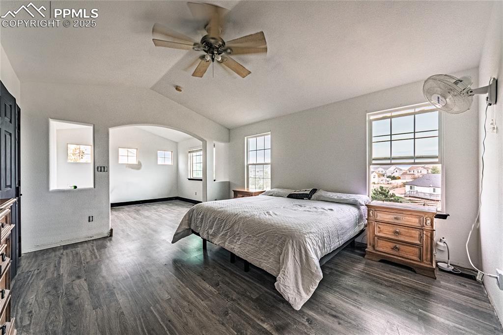 Image 32 of 47: Bedroom with dark wood finished floors, lofted ceiling, a ceiling fan, and 
