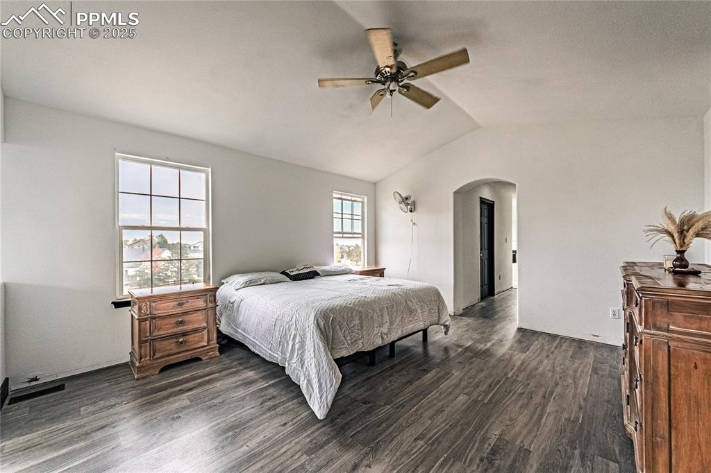 Image 33 of 47: Bedroom featuring dark wood-style flooring, vaulted ceiling, ceiling fan, a