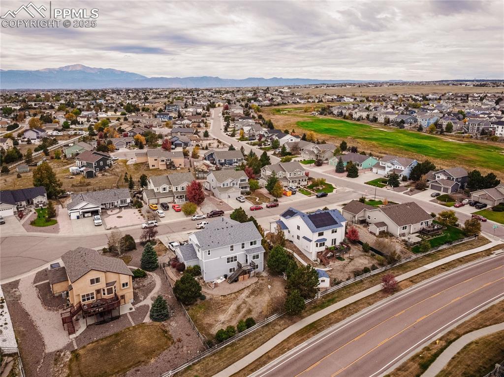 Image 41 of 47: Aerial view of residential area featuring a mountainous background
