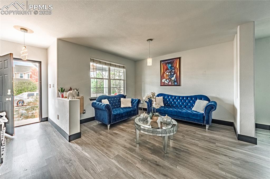 Image 5 of 47: Living room featuring wood finished floors and a textured ceiling