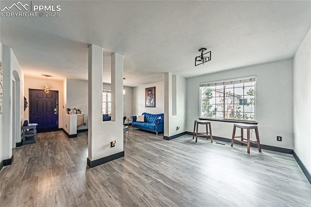Image 7 of 47: Living room featuring wood finished floors and a textured ceiling