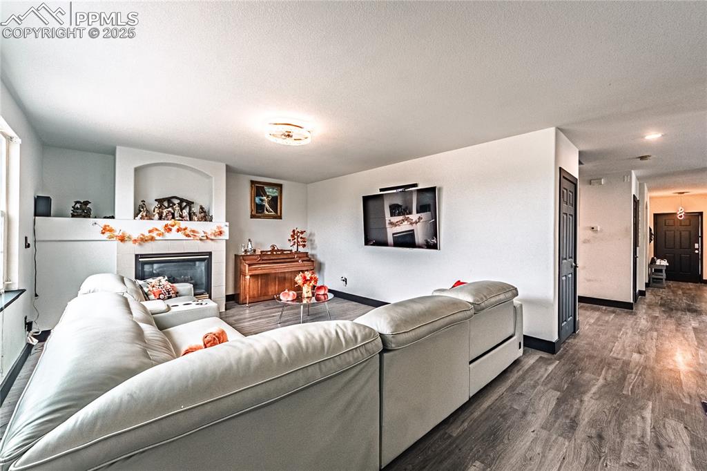 Image 8 of 47: Living room featuring wood finished floors and a fireplace