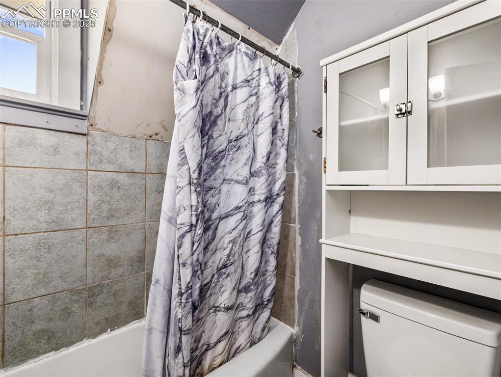 Image 15 of 30: Full bath with shower / bathtub combination with curtain and toilet
