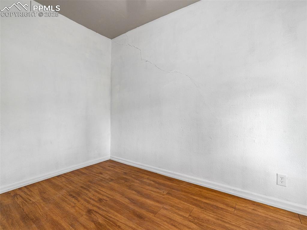 Image 24 of 30: Unfurnished room with baseboards and wood finished floors