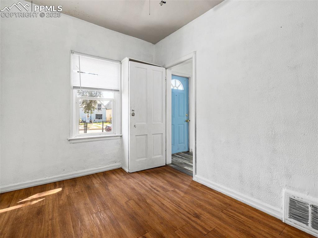 Image 25 of 30: Unfurnished room with wood finished floors and a textured wall