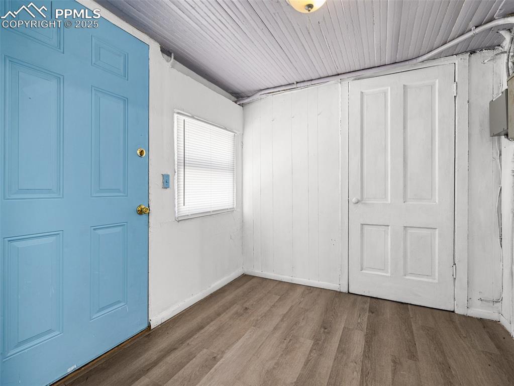 Image 26 of 30: rear entrance with dark wood-style floors and baseboards