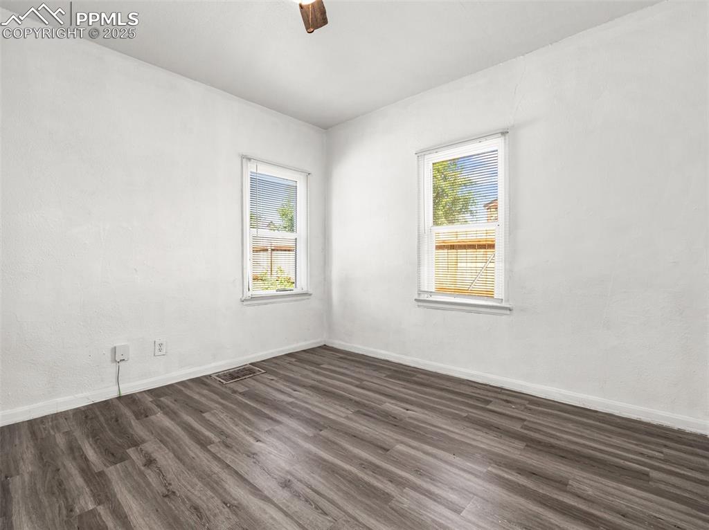 Image 29 of 30: bedroom with dark wood-style flooring, healthy amount of natural light, and