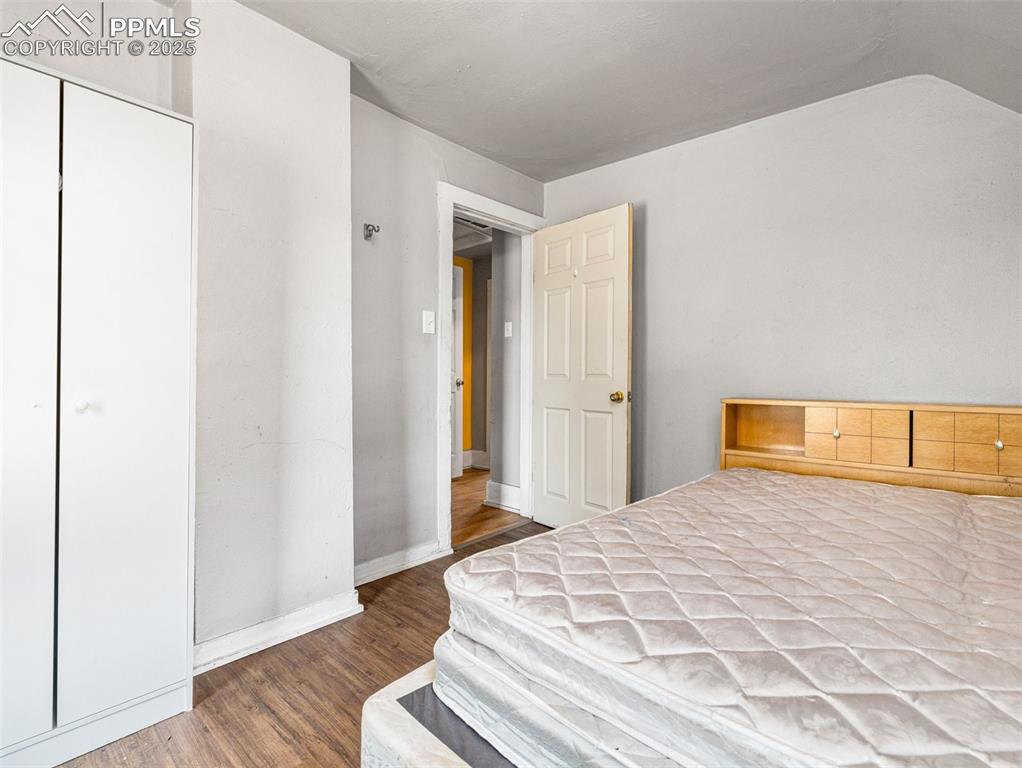 Image 6 of 30: Bedroom featuring dark wood finished floors and a closet