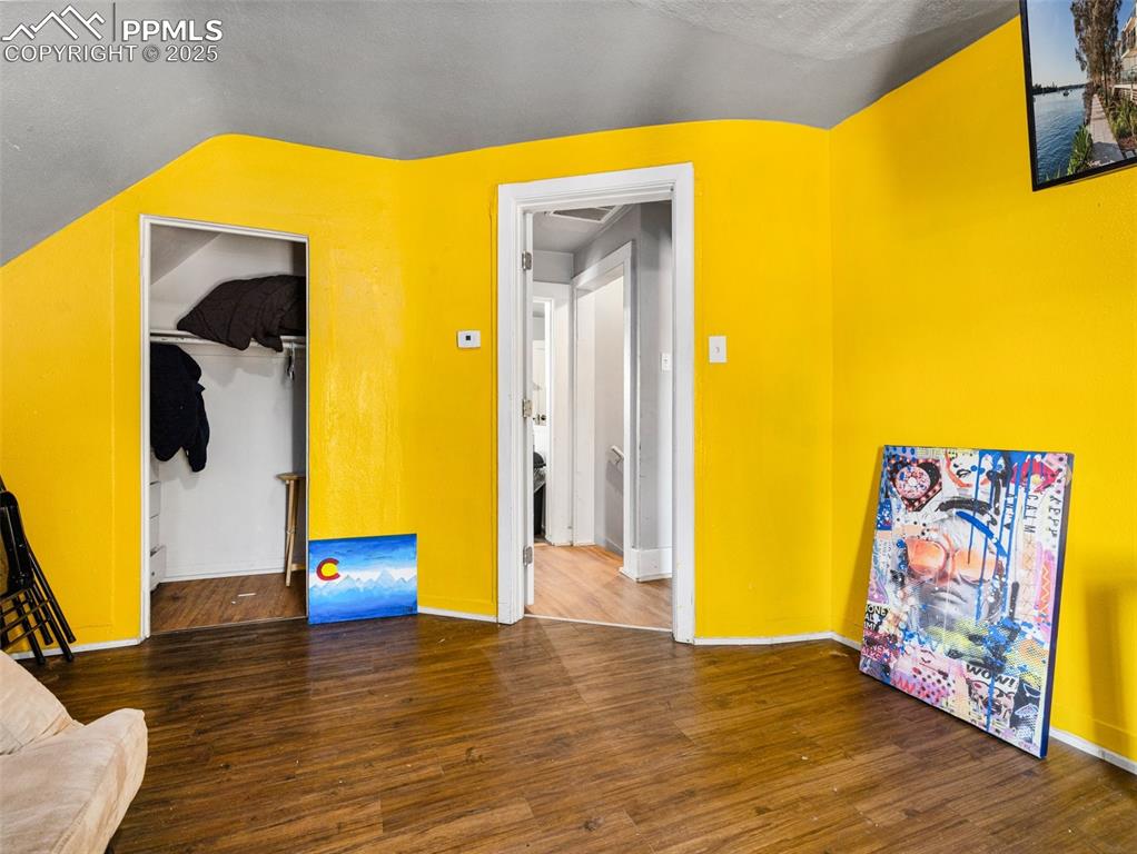 Image 8 of 30: Additional living space with dark wood finished floors and lofted ceiling