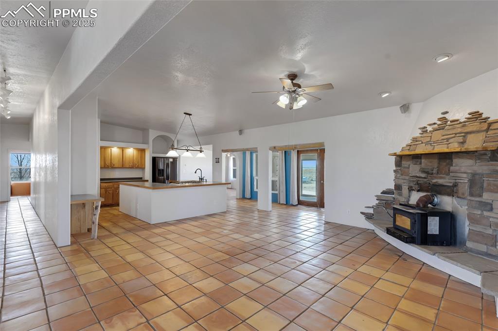 Image 8 of 43: Kitchen featuring a ceiling fan, open floor plan, light tile patterned floo