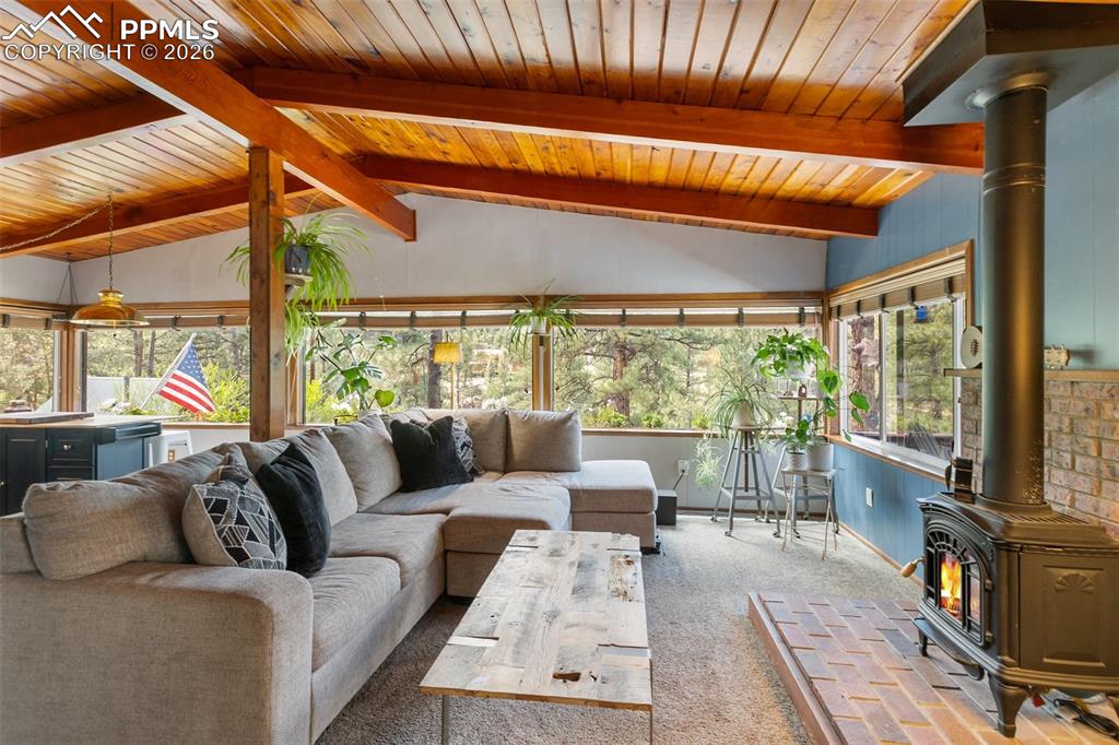 Image 12 of 46: Living area with a gas stove and beautiful wood ceiling