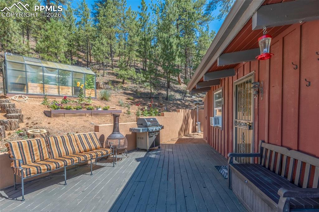 Image 35 of 46: Wooden deck with a greenhouse, area for grilling