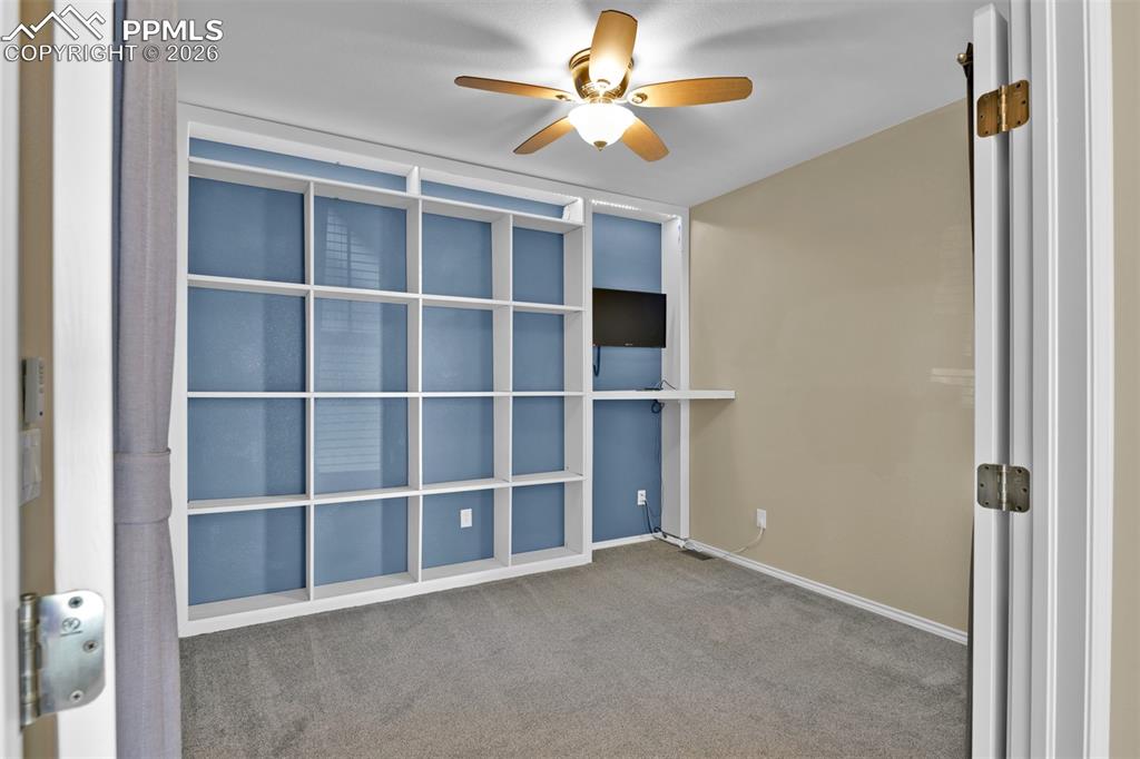 Image 12 of 50: Office on the main level with French doors and built-in shelves