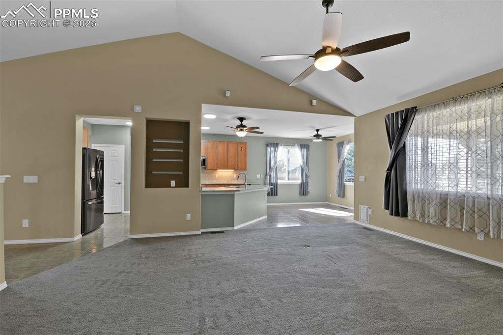 Image 18 of 50: Living room with vaulted ceilig