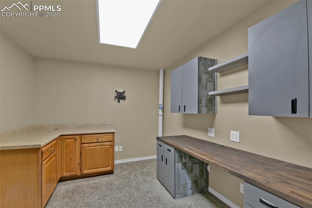 Image 42 of 50: Basement office with cabinets
