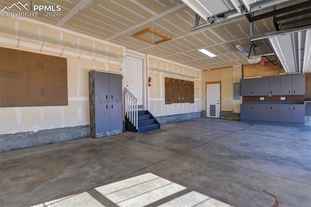 Image 43 of 50: 3 car garage with cabinets 