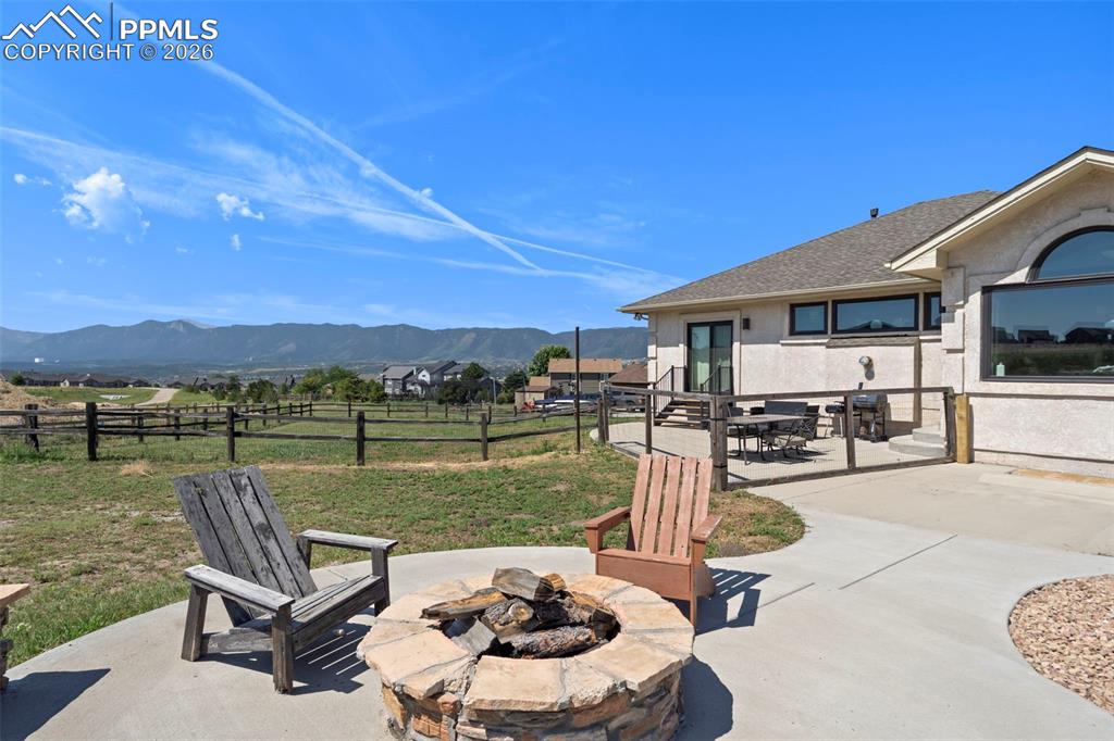 Image 10 of 47: Fenced backyard with a mountain view and fire pit extra concrete patio and