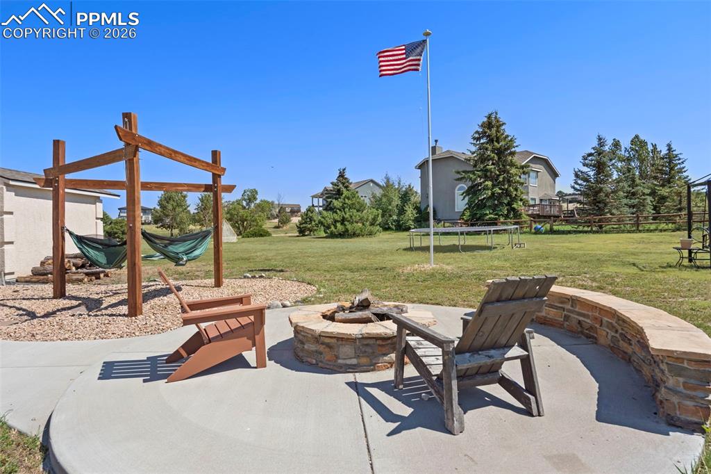 Image 11 of 47: View of patio featuring a trampoline, hammock station and a fire pit