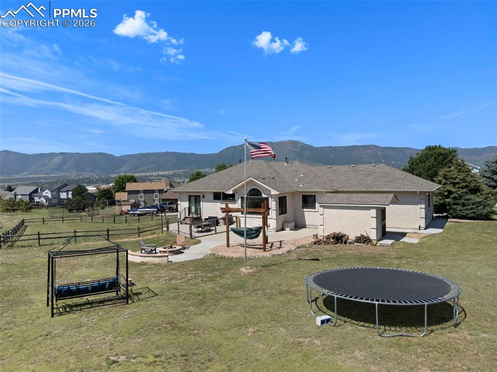 Image 14 of 47: Back of property featuring a mountain view, a patio, a fire pit, and space