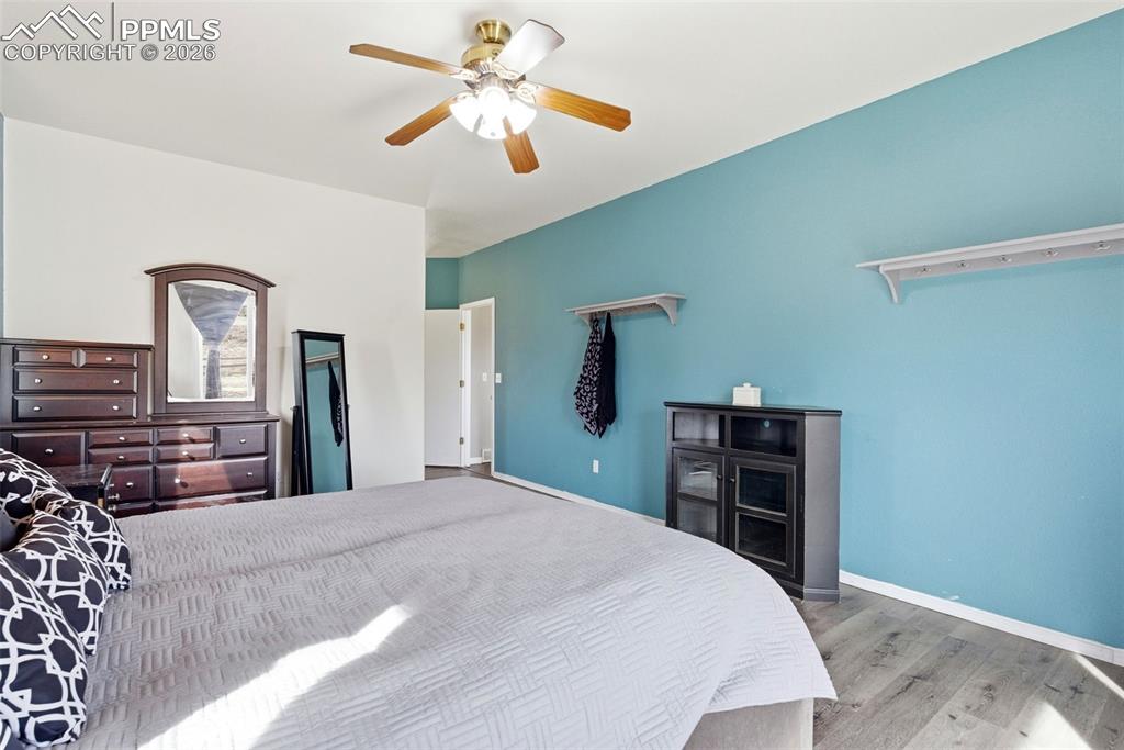 Image 36 of 47: Master bedroom with light grey wood-style flooring