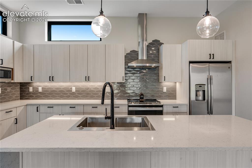 Image 2 of 45: Kitchen with Waterfall Quartz Kitchen Island