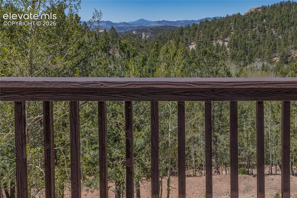 Image 2 of 50: Home sits among mature pine trees in a peaceful setting.