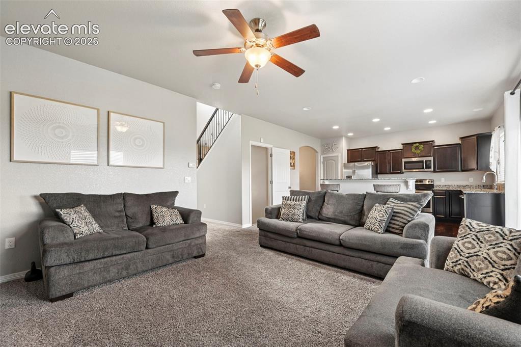 Image 10 of 29: Open-concept living area featuring carpeted flooring and an overhead ceilin