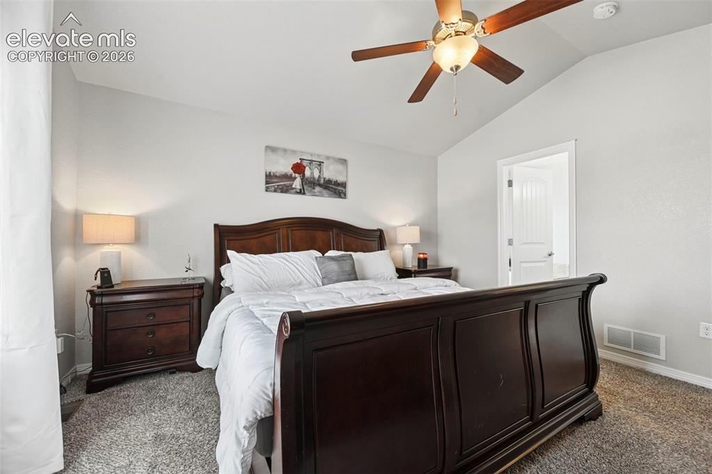Image 12 of 29: Vaulted ceiling, ceiling fan with integrated lighting, textured carpeting,