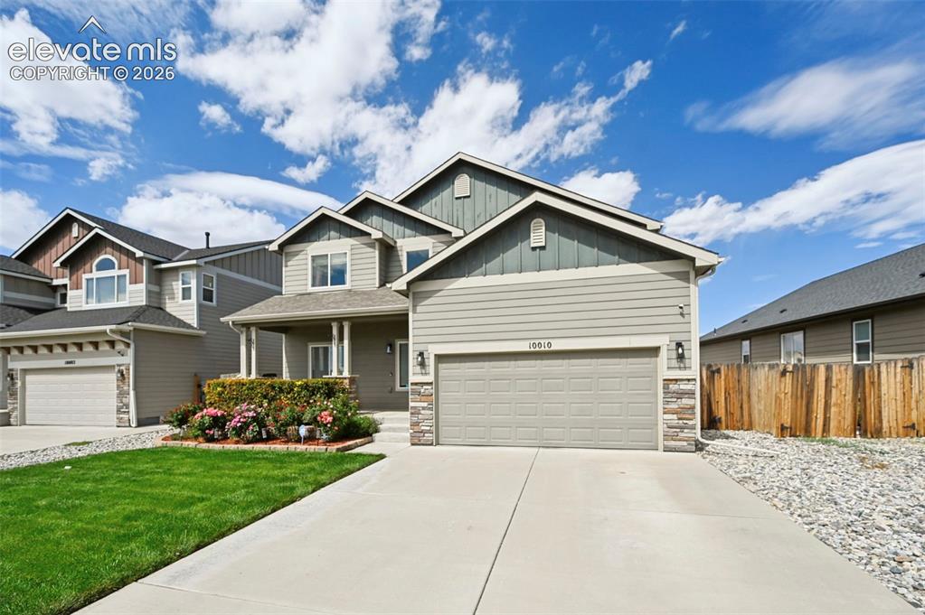 Image 23 of 29: Two-story residence featuring a covered entry porch, an attached two-car ga