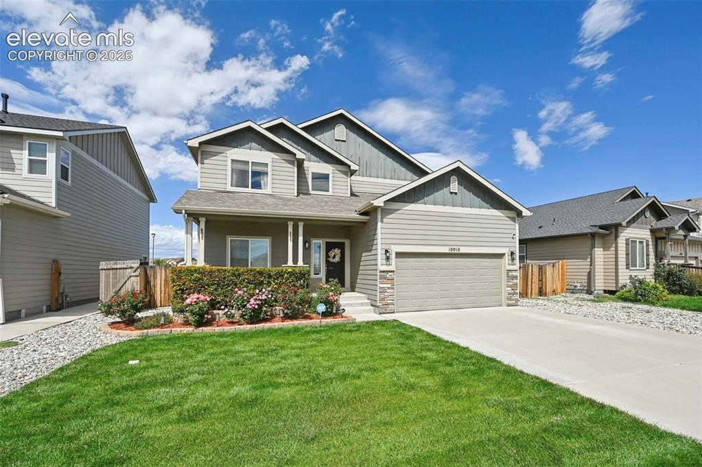 Image 24 of 29: Two-story residence featuring composite siding, an attached garage, a cover