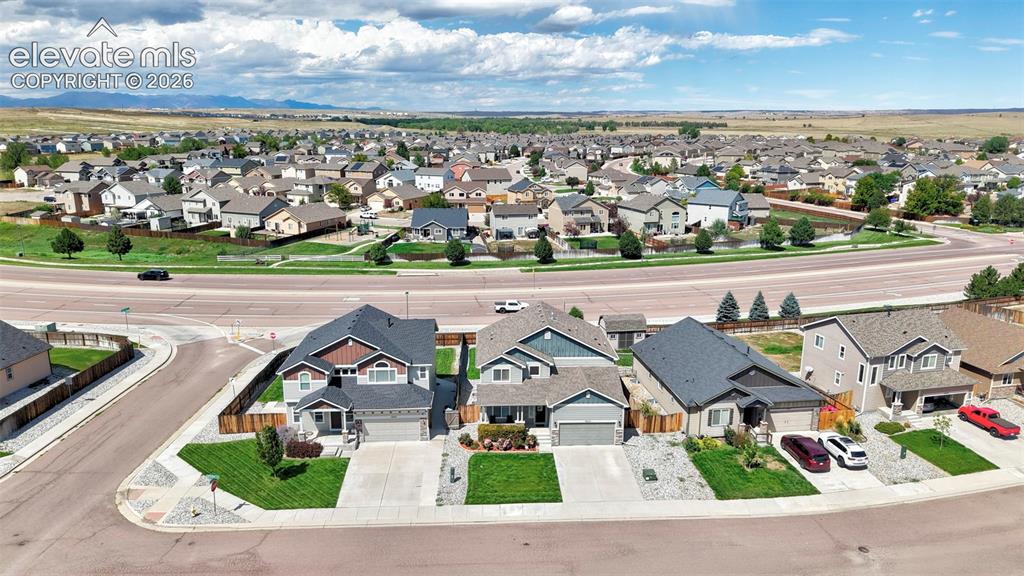 Image 25 of 29: Residential neighborhood with single-family homes, paved streets, and manic