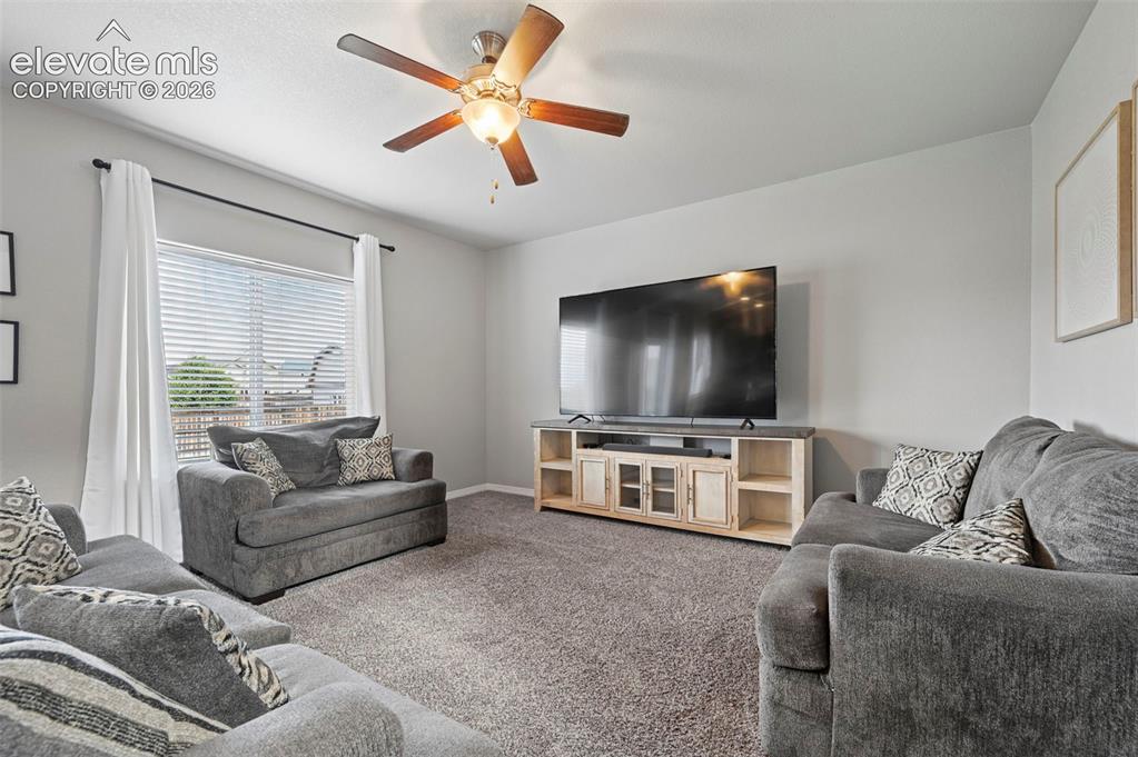Image 8 of 29: Textured carpet flooring, ceiling fan with integrated lighting, window with