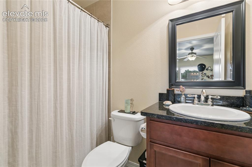 Image 14 of 28: Bathroom featuring a dark wood-finish vanity with a black granite-style cou
