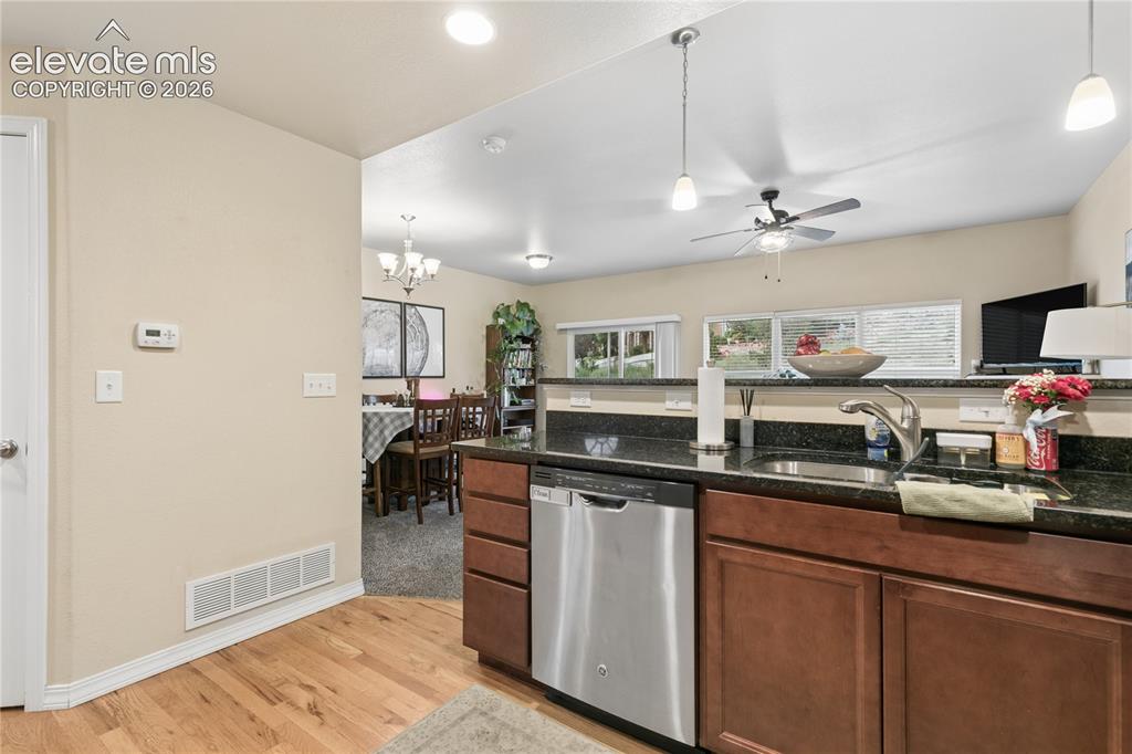 Image 17 of 28: Kitchen featuring wood-finish flooring, dark wood cabinetry, and a dark sto