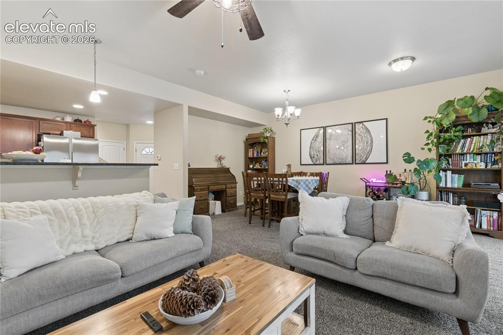 Image 7 of 28: Open-concept living area featuring neutral-toned walls, gray carpeting, a c